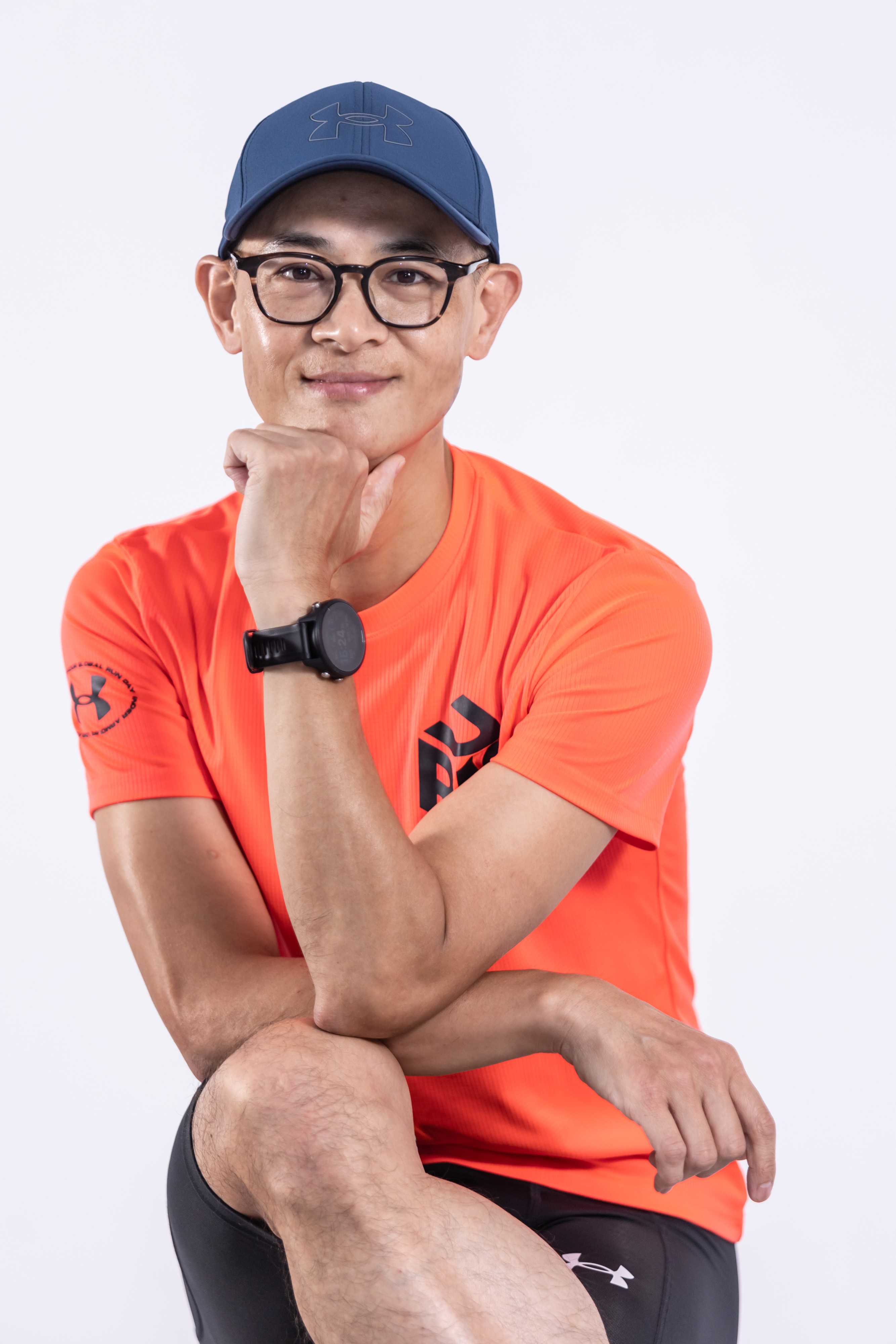 Coach Hank 陳政翰教練，戴藍色帽子及眼鏡、穿橘色運動上衣的個人照片